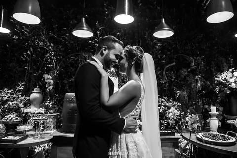 retrato dos noivos em frente a decoração do casamento em preto e branco '