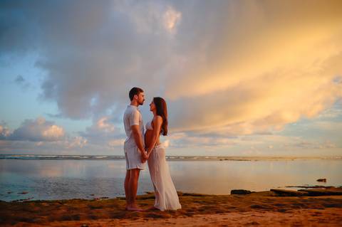 Registro emocionante do pôr do sol em Praia do Forte-Ba, onde o casal celebra a chegada iminente de seu filho.'