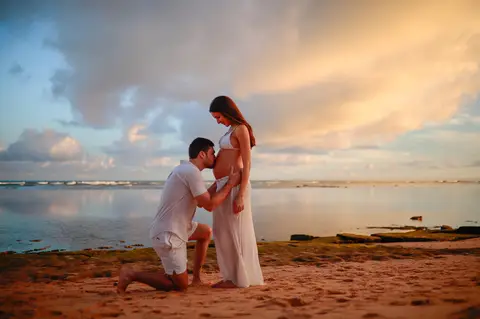 Registro emocionante do pôr do sol em Praia do Forte-Ba, onde o casal celebra a chegada iminente de seu filho.'