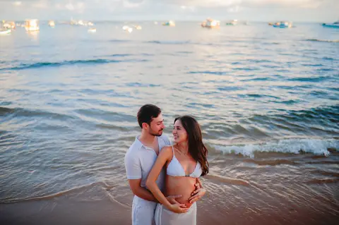 Ensaio fotográfico deslumbrante em Praia do Forte-Ba captura o amor e a expectativa do casal à espera do bebê.'