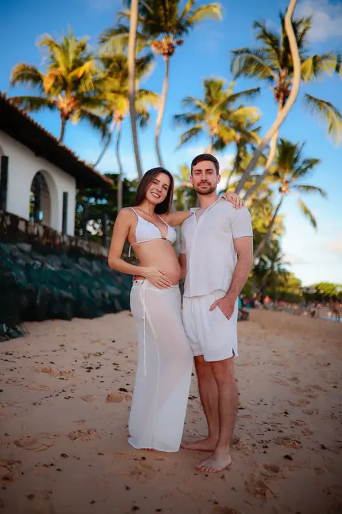 Ensaio fotográfico deslumbrante em Praia do Forte-Ba captura o amor e a expectativa do casal à espera do bebê.'