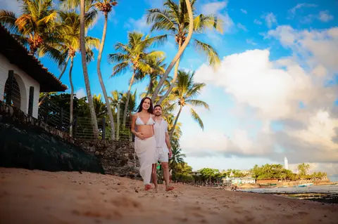 Ensaio fotográfico deslumbrante em Praia do Forte-Ba captura o amor e a expectativa do casal à espera do bebê.'