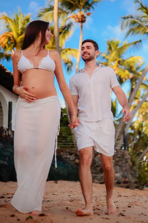 Ensaio fotográfico deslumbrante em Praia do Forte-Ba captura o amor e a expectativa do casal à espera do bebê.'