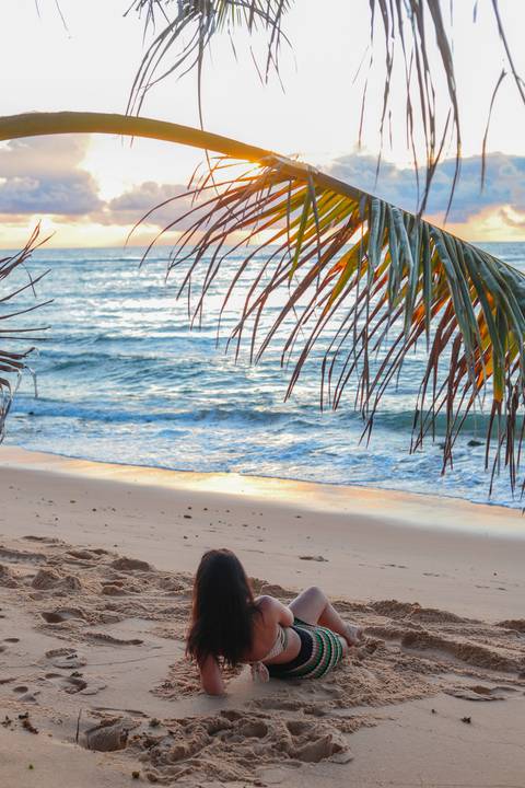 A magia do amanhecer na Bahia: Kira Mizk brilha sob a luz suave do sol nascente na Praia do Forte.'
