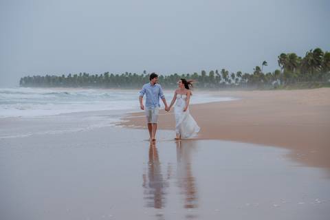 Casal se banha de mar e chuva em ensaio romântico na Bahia. Registro autêntico para quem busca fotografia de casamento com emoção.'