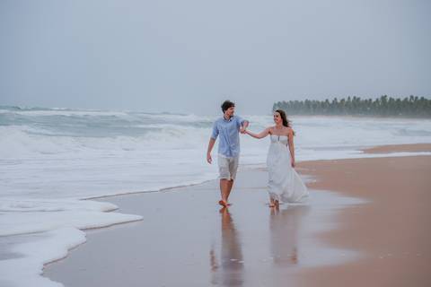 Casal se banha de mar e chuva em ensaio romântico na Bahia. Registro autêntico para quem busca fotografia de casamento com emoção.'