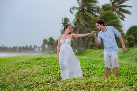 Casal se banha de mar e chuva em ensaio romântico na Bahia. Registro autêntico para quem busca fotografia de casamento com emoção.'