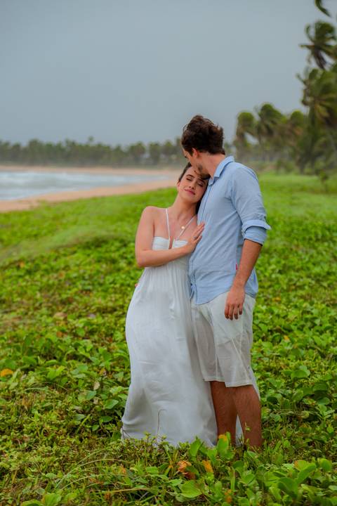 Casal se banha de mar e chuva em ensaio romântico na Bahia. Registro autêntico para quem busca fotografia de casamento com emoção.'