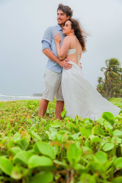 Casal se banha de mar e chuva em ensaio romântico na Bahia. Registro autêntico para quem busca fotografia de casamento com emoção.'
