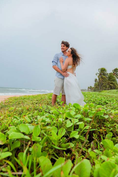 Casal se banha de mar e chuva em ensaio romântico na Bahia. Registro autêntico para quem busca fotografia de casamento com emoção.'