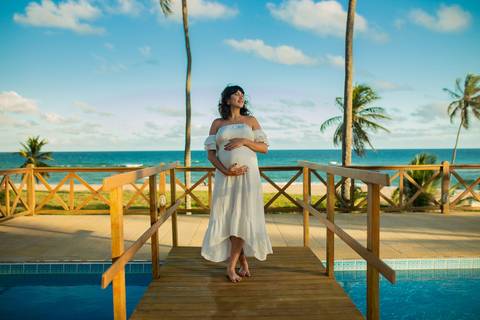 Maria Paula grávida, sorrindo ao lado de Bruno, em momento de afeto registrado por Waldyr Lantyer, fotógrafo especializado em ensaios gestantes em Praia do Forte Bahia e áreas como o Iberostar.'