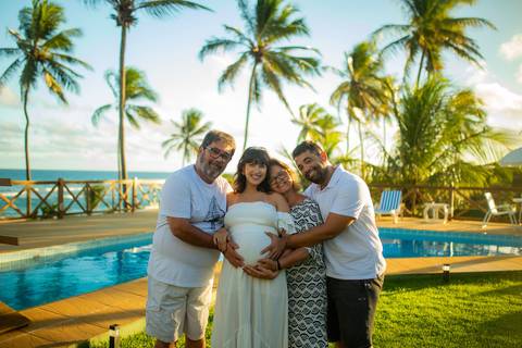Maria Paula grávida, sorrindo ao lado de Bruno, em momento de afeto registrado por Waldyr Lantyer, fotógrafo especializado em ensaios gestantes em Praia do Forte Bahia e áreas como o Iberostar.'