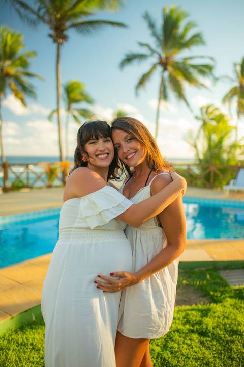 Fotografia gestante no pôr do sol em Barra do Jacuípe, com casal e cachorro, realizada por Waldyr Lantyer, fotógrafo em Praia do Forte Bahia, próximo ao Iberostar e Guarajuba.'
