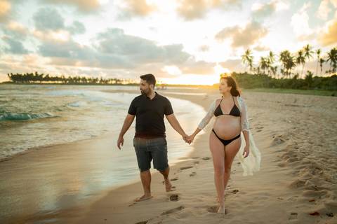 Gestante contemplando o mar com vestido branco esvoaçante, na varanda de casa próxima ao Iberostar, em ensaio realizado por Waldyr Lantyer, fotógrafo da Praia do Forte Bahia.
asal em abraço carinhoso à beira-mar, com vegetação tropical ao fundo, capturad
'