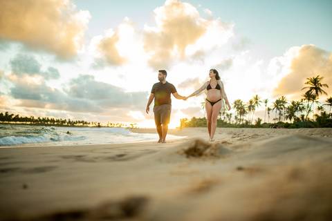 Gestante contemplando o mar com vestido branco esvoaçante, na varanda de casa próxima ao Iberostar, em ensaio realizado por Waldyr Lantyer, fotógrafo da Praia do Fasal em abraço carinhoso à beira-mar, com vegetação tropical ao fundo, capturadorte Bahia.

'
