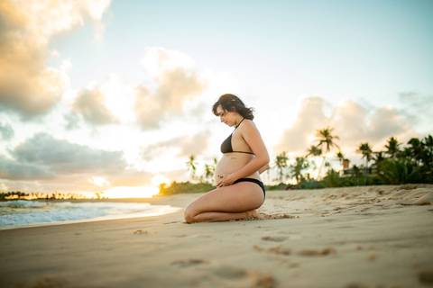 Gestante contemplando o mar com vestido branco esvoaçante, na varanda de casa próxima ao Iberostar, em ensaio realizado por Waldyr Lantyer, fotógrafo da Praia do Forte Bahia.
asal em abraço carinhoso à beira-mar, com vegetação tropical ao fundo, capturad
'