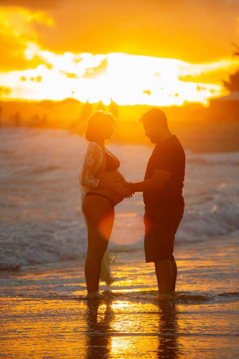 Família com cachorro participando do ensaio gestante na areia da praia, com fotografia afetiva de Waldyr Lantyer, fotógrafo da Praia do Forte Bahia, com atendimento próximo ao Iberostar.'