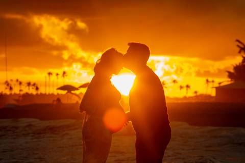 Família com cachorro participando do ensaio gestante na areia da praia, com fotografia afetiva de Waldyr Lantyer, fotógrafo da Praia do Forte Bahia, com atendimento próximo ao Iberostar.'