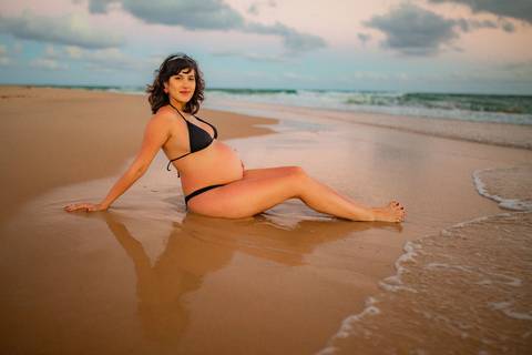 Família com cachorro participando do ensaio gestante na areia da praia, com fotografia afetiva de Waldyr Lantyer, fotógrafo da Praia do Forte Bahia, com atendimento próximo ao Iberostar.'