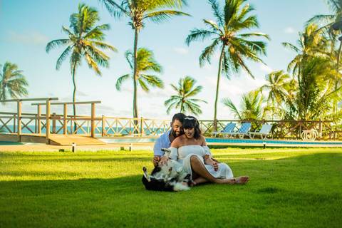 Gestante de branco deitada na rede com o marido em casa de praia em Barra do Jacuípe, próximo ao Iberostar, em ensaio realizado por Waldyr Lantyer, fotógrafo na Praia do Forte Bahia.'