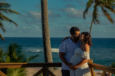 Casal mineiro trocando carinho na rede em varanda com vista para o mar, em ensaio gestacional produzido por Waldyr Lantyer, fotógrafo especializado na Praia do Forte Bahia e região do Iberostar.'