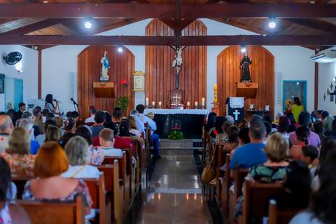 Ensaio de família em Praia do Forte com pais e filha durante o batismo — fotografia afetiva e natural realizada por Waldyr Lantyer.'