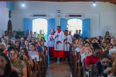 Ensaio de família em Praia do Forte com pais e filha durante o batismo — fotografia afetiva e natural realizada por Waldyr Lantyer.'