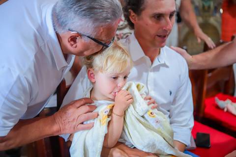 Ensaio de batizado com pais e padrinhos em cenário natural na Praia do Forte — experiência de fé e conexão familiar.'