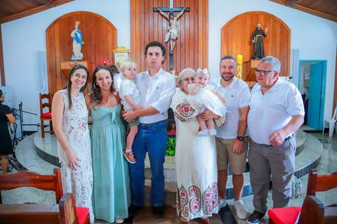 Fotografia ao ar livre na Bahia durante batizado familiar — cenário tropical e luz natural favorecem o registro afetivo.'