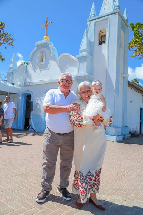Entrada da igreja histórica de Praia do Forte no momento do batizado infantil — fotografia documental.'