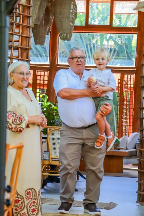 Família reunida na Pousada Refúgio da Vila celebrando o batismo de Catarina com simplicidade e aconchego.'