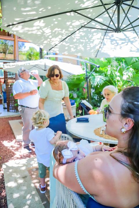 Família reunida na Pousada Refúgio da Vila celebrando o batismo de Catarina com simplicidade e aconchego.'
