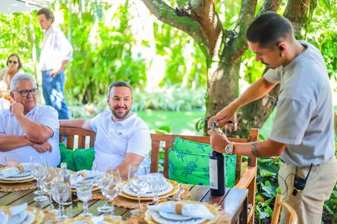Recepção intimista do batizado na Refúgio da Vila, em Praia do Forte — momento especial capturado por Waldyr Lantyer.'