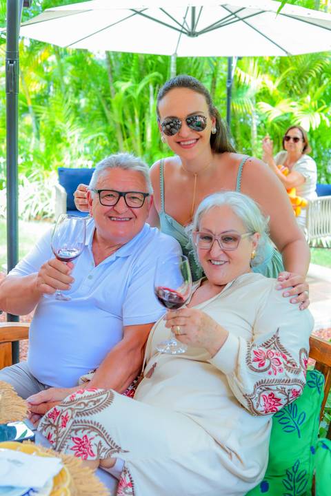 Momentos de carinho e união entre gerações durante o batismo em Praia do Forte, captados por Waldyr Lantyer.'
