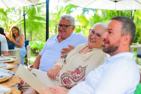 Momentos de carinho e união entre gerações durante o batismo em Praia do Forte, captados por Waldyr Lantyer.'