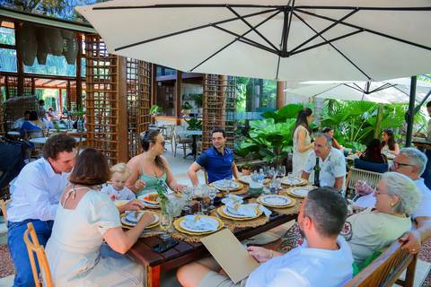 Momentos de carinho e união entre gerações durante o batismo em Praia do Forte, captados por Waldyr Lantyer.'