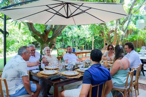 Momentos de carinho e união entre gerações durante o batismo em Praia do Forte, captados por Waldyr Lantyer.'