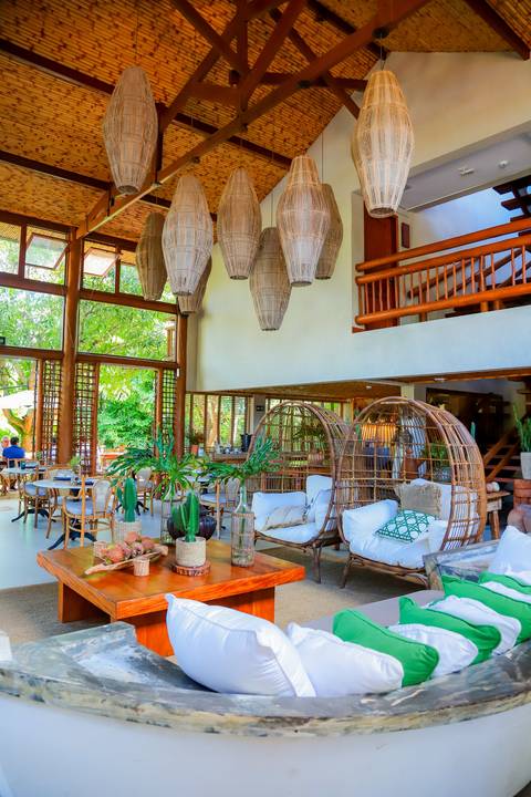 Recepção intimista do batismo de Catarina na charmosa Pousada Refúgio da Vila, Praia do Forte, cercada por natureza e afeto em família.'