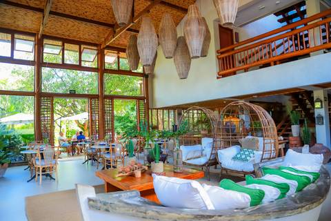 Recepção intimista do batismo de Catarina na charmosa Pousada Refúgio da Vila, Praia do Forte, cercada por natureza e afeto em família.'