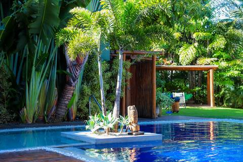 Área verde e aconchegante do Refúgio da Vila, com paisagismo encantador que harmoniza natureza e elegância na Praia do Forte.'