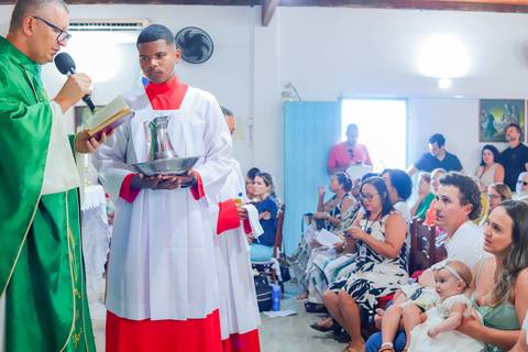 Ensaio de família em Praia do Forte com pais e filha durante o batismo — fotografia afetiva e natural realizada por Waldyr Lantyer.'