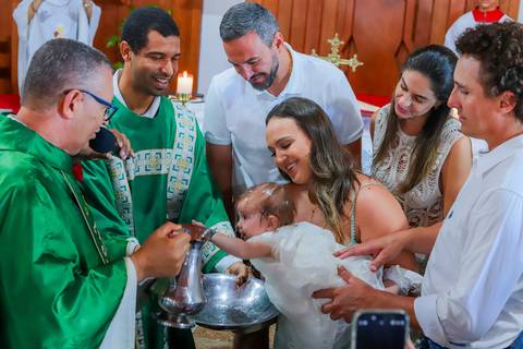 Família reunida na recepção do batizado na Pousada Refúgio da Vila, em Praia do Forte — momento de carinho e celebração em espaço acolhedor.'