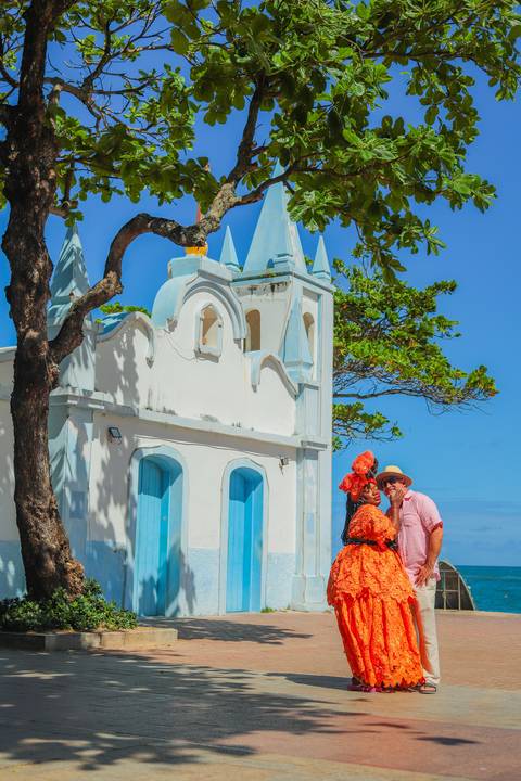 Sorriso espontâneo capturado diante do Projeto Tamar em Praia do Forte. Fotógrafo em Salvador e Litoral Norte da Bahia, ideal para famílias, casais e viajantes.Registro autêntico com a baiana sem freio em frente à igreja de São Francisco.'