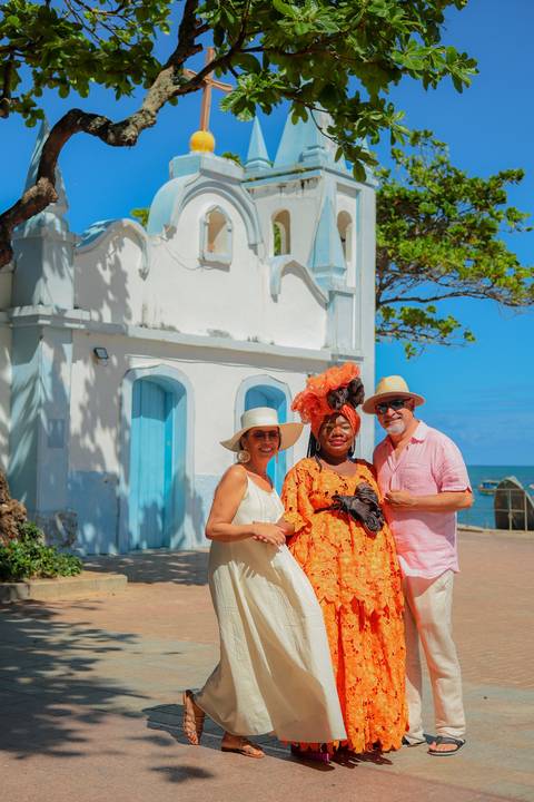 Sorriso espontâneo capturado diante do Projeto Tamar em Praia do Forte. Fotógrafo em Salvador e Litoral Norte da Bahia, ideal para famílias, casais e viajantes.Registro autêntico com a baiana sem freio em frente à igreja de São Francisco.'