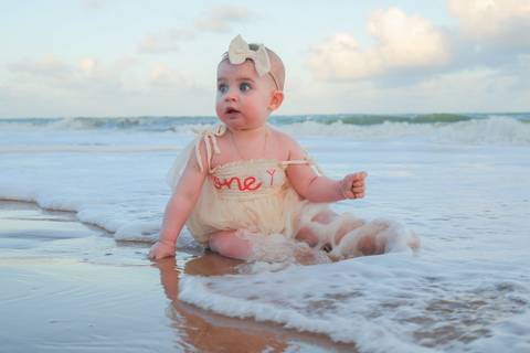 Entre a ternura dos avós e o carinho dos pais, Celine foi o centro de um dia repleto de afeto. O ensaio fotográfico na Praia do Forte foi uma verdadeira celebração da vida, da união e da beleza das gerações em família.'
