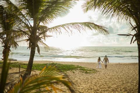 Ensaio gestacional ao nascer do sol em Imbassaí, no encontro do rio com o mar — cenário perfeito para fotografia de gravidez no litoral norte da Bahia.'