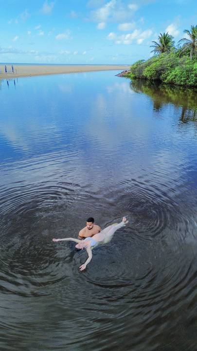 Ensaio gestacional ao nascer do sol em Imbassaí, no encontro do rio com o mar — cenário perfeito para fotografia de gravidez no litoral norte da Bahia.'