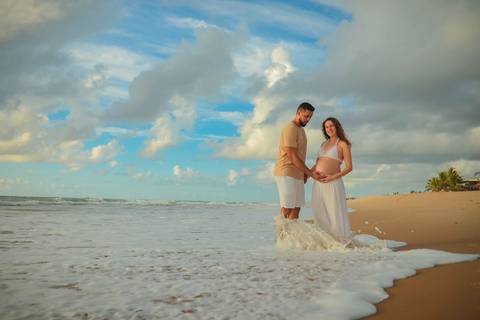 Ensaio gestacional ao nascer do sol em Imbassaí, no encontro do rio com o mar — cenário perfeito para fotografia de gravidez no litoral norte da Bahia.'