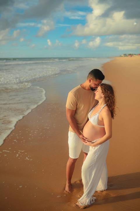 Ensaio gestacional ao nascer do sol em Imbassaí, no encontro do rio com o mar — cenário perfeito para fotografia de gravidez no litoral norte da Bahia.'