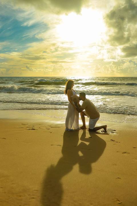 Ensaio gestacional ao nascer do sol em Imbassaí, no encontro do rio com o mar — cenário perfeito para fotografia de gravidez no litoral norte da Bahia.'